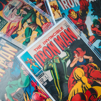 Image shows a messy pile of Marvel comic books in plastic wallets, including several about Iron Man