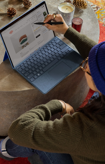 Image shows a person sitting on the floor looking at a website on their laptop