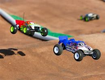 Image shows 2 radio controlled cars catching some air as they go over bumps in the racing track